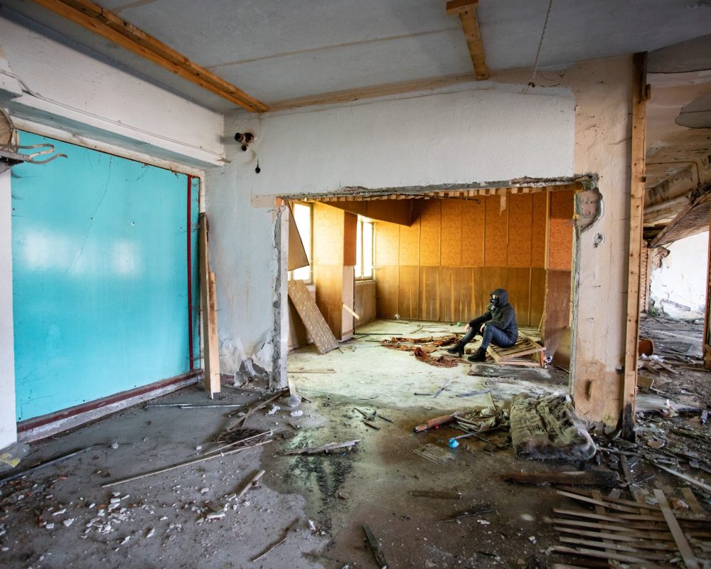 Post apocalyptic survivor in gas mask in a ruined building. Environmental disaster, armageddon concept.